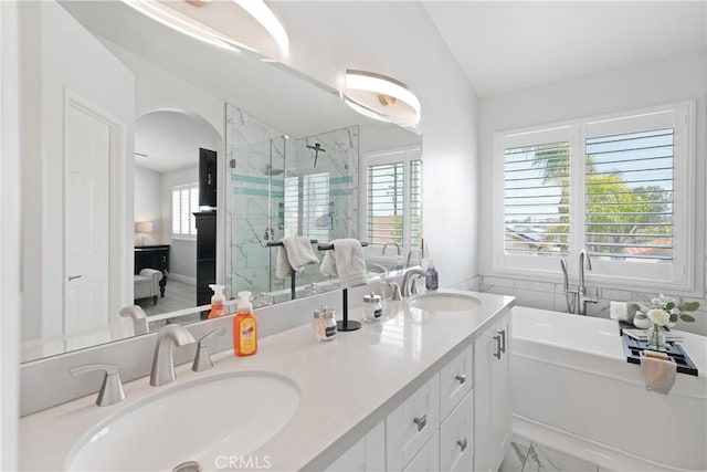 bathroom featuring double vanity, a shower stall, a sink, and lofted ceiling
