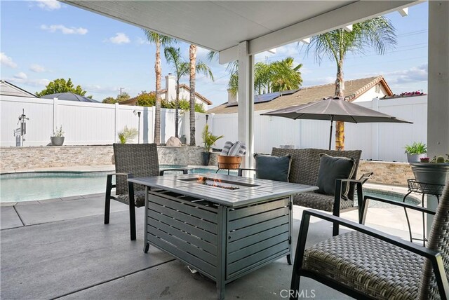 view of patio with a fenced in pool, a fenced backyard, and an outdoor fire pit