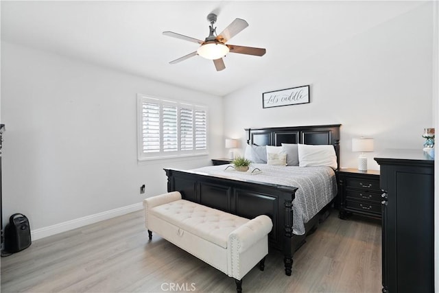 bedroom with baseboards, ceiling fan, vaulted ceiling, and wood finished floors