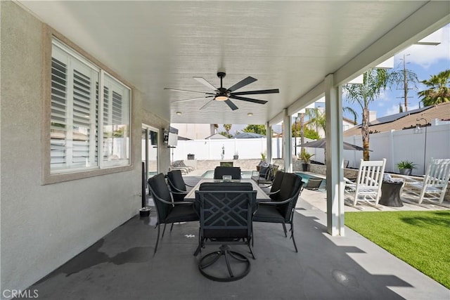 view of patio / terrace featuring a fenced backyard, an outdoor living space with a fire pit, ceiling fan, and outdoor dining area