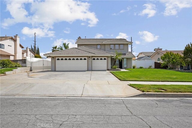 traditional-style house featuring a front yard, a gate, a garage, fence, and concrete driveway