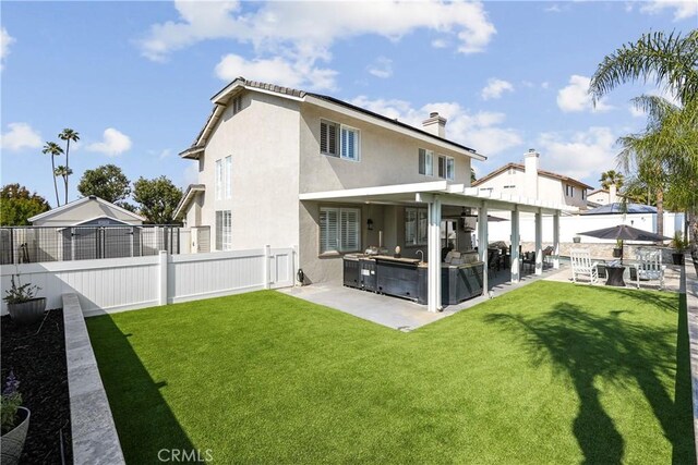 back of house with a patio, a fenced backyard, a lawn, and area for grilling