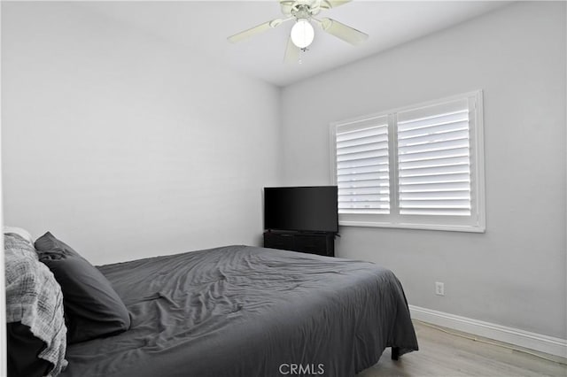 bedroom with baseboards, ceiling fan, and wood finished floors