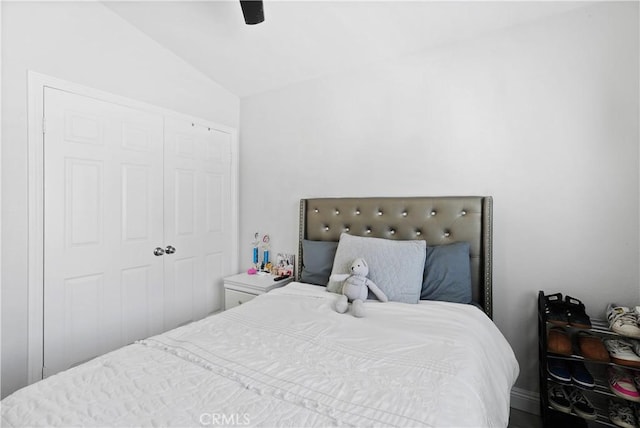 bedroom with a ceiling fan, vaulted ceiling, and a closet