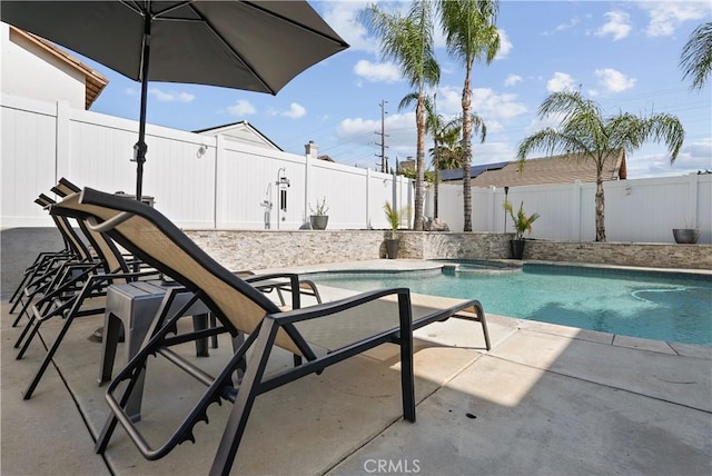view of swimming pool featuring a fenced backyard, a patio area, and a pool with connected hot tub