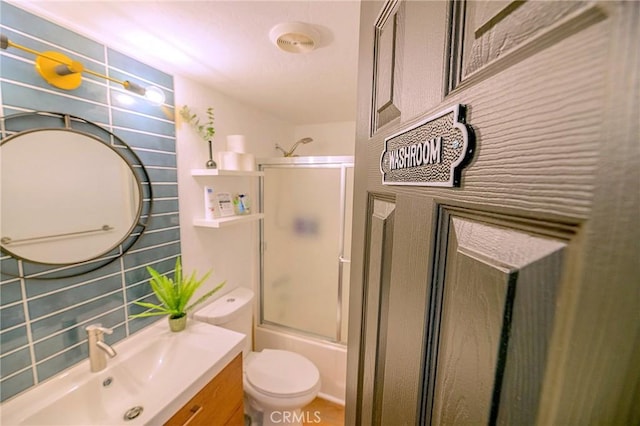 full bathroom featuring vanity, decorative backsplash, enclosed tub / shower combo, and toilet
