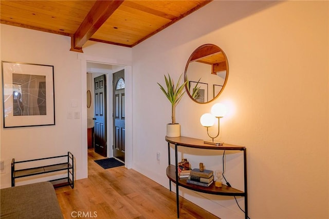 hallway featuring beam ceiling, wood ceiling, and light wood finished floors