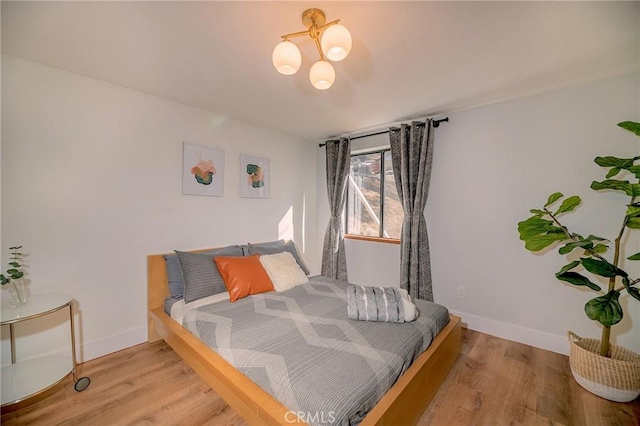 bedroom with baseboards and wood finished floors
