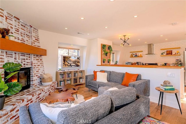 living room featuring visible vents, recessed lighting, light wood finished floors, and a fireplace