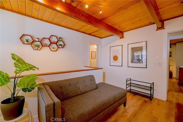 sitting room with wood finished floors, beam ceiling, and wooden ceiling