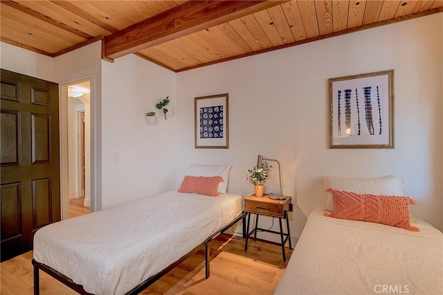 bedroom with crown molding, wooden ceiling, light wood-type flooring, and beam ceiling