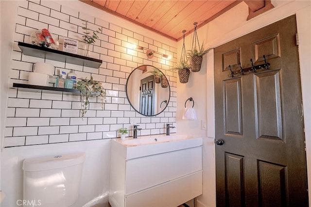 bathroom with decorative backsplash, toilet, wooden ceiling, and vanity