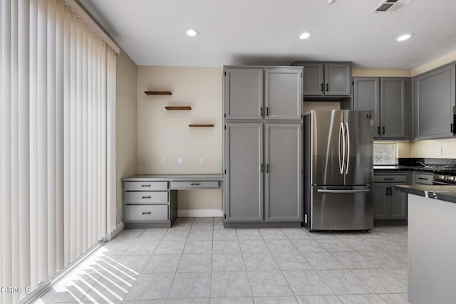 834 Corte Baya Vis, Oxnard, CA 93030 - kitchen featuring dark countertops, built in desk, visible vents, freestanding refrigerator, and gray cabinetry