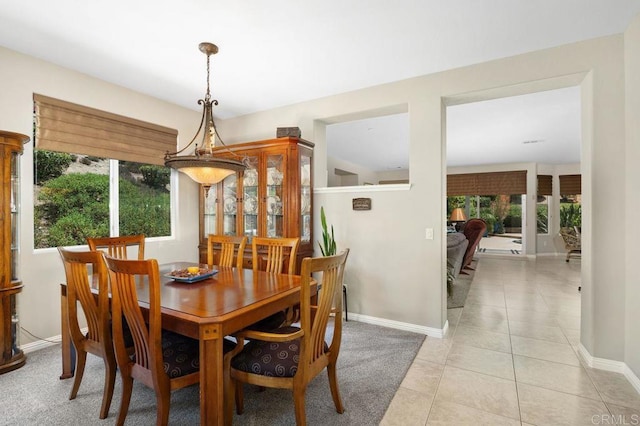 dining area with light tile patterned flooring, baseboards, and a wealth of natural light