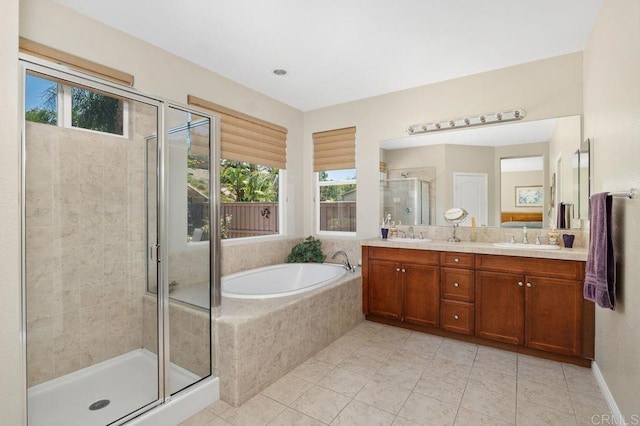 full bathroom featuring a healthy amount of sunlight, tile patterned floors, a shower stall, and a sink