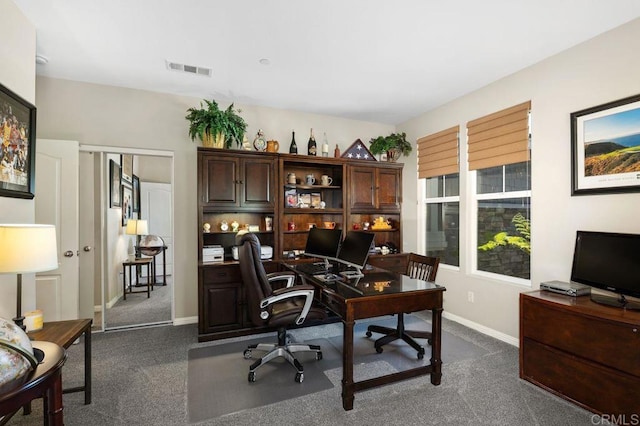 office area with baseboards, visible vents, and dark carpet