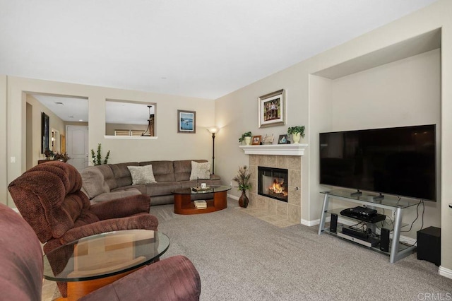 carpeted living room featuring baseboards and a fireplace