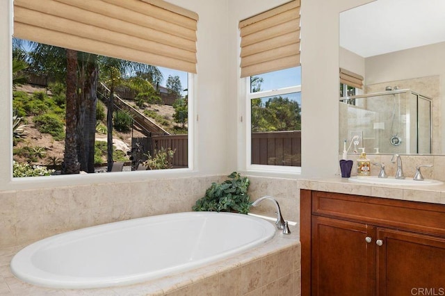 full bathroom featuring vanity, a shower stall, and a garden tub