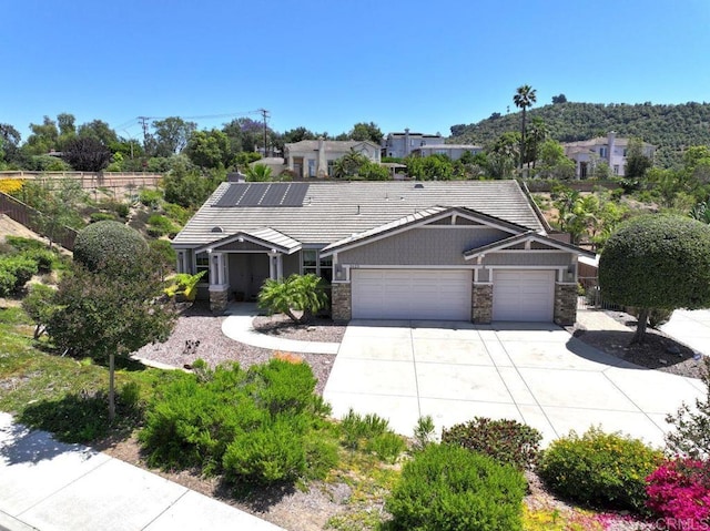 ranch-style house with a garage, stone siding, and concrete driveway