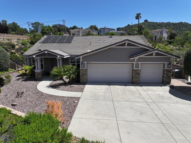 view of front of home featuring an attached garage, driveway, and stone siding