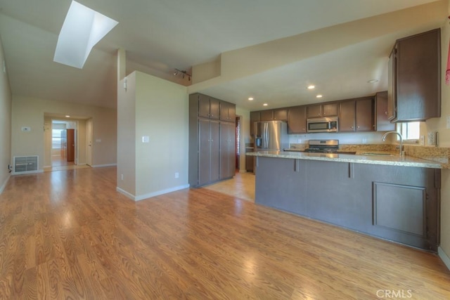 24731 Huntley Dr, Moreno Valley, CA 92557 - kitchen featuring a sink, light wood finished floors, stainless steel appliances, a peninsula, and visible vents