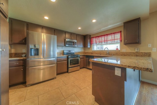 24731 Huntley Dr, Moreno Valley, CA 92557 - kitchen with a sink, baseboards, a peninsula, stainless steel appliances, and recessed lighting
