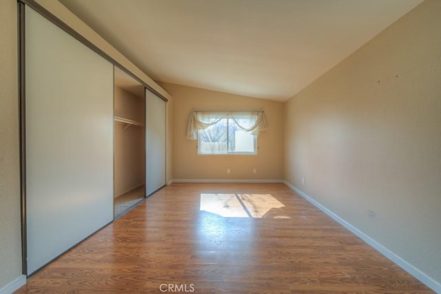 24731 Huntley Dr, Moreno Valley, CA 92557 - unfurnished bedroom with a closet, baseboards, vaulted ceiling, and wood finished floors