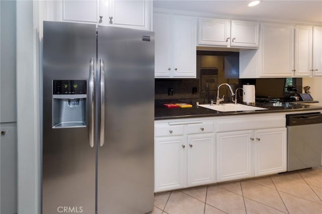 kitchen with a sink, light tile patterned floors, white cabinets, and stainless steel appliances