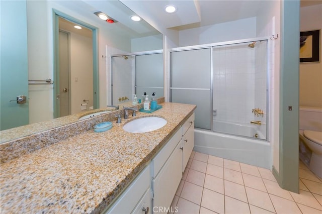 full bathroom with toilet, bath / shower combo with glass door, tile patterned flooring, and vanity