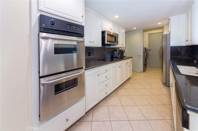 kitchen featuring appliances with stainless steel finishes, decorative backsplash, and white cabinetry