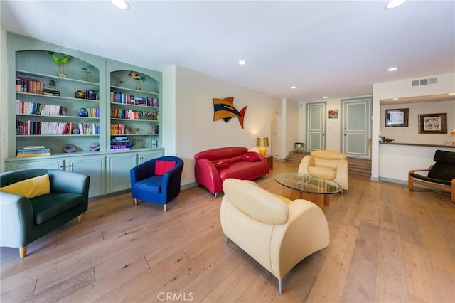 living room featuring visible vents, recessed lighting, light wood-style flooring, and built in features