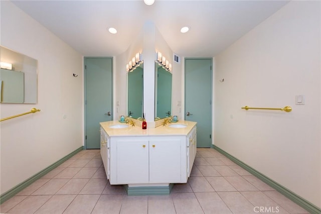 full bath featuring a sink, tile patterned floors, baseboards, and double vanity