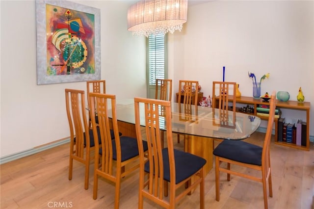 dining area with wood finished floors and a chandelier