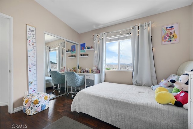 bedroom with baseboards, wood finished floors, and vaulted ceiling