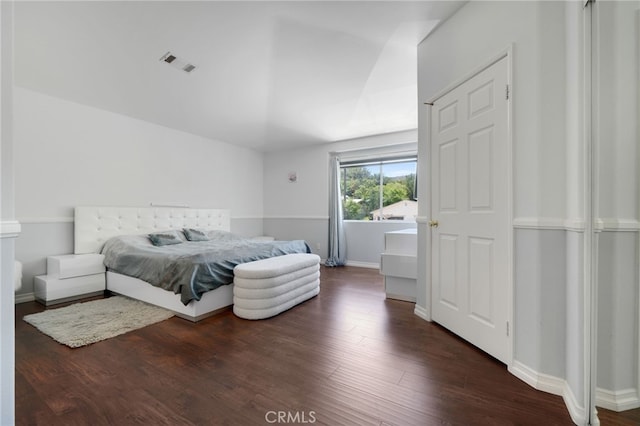 bedroom with baseboards, visible vents, and dark wood finished floors