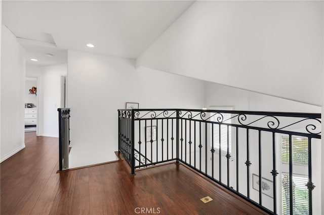 corridor featuring recessed lighting, baseboards, dark wood finished floors, and an upstairs landing