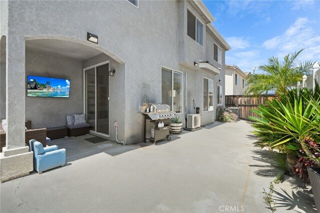 back of property with a patio, ac unit, stucco siding, and fence