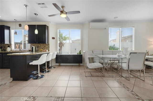 dining space featuring visible vents, crown molding, a wall mounted air conditioner, a ceiling fan, and light tile patterned floors