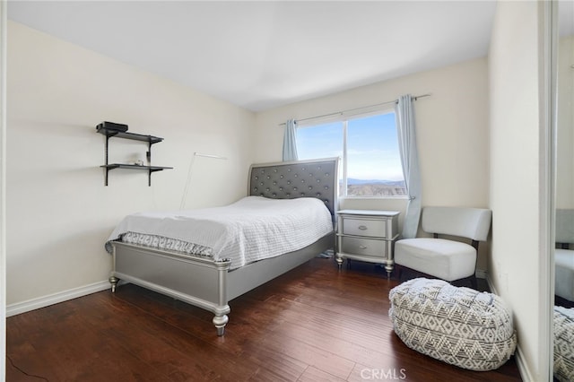 bedroom with baseboards and wood finished floors