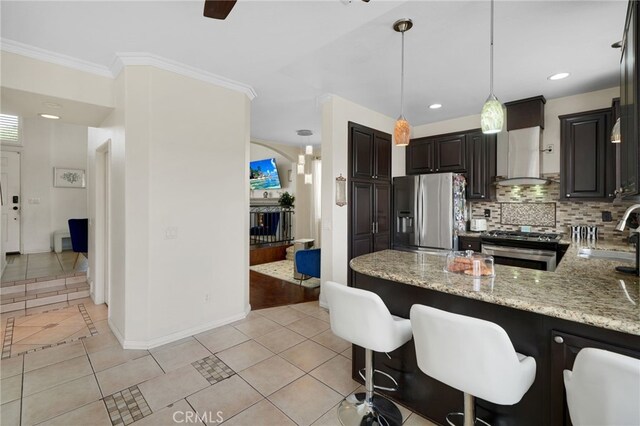 kitchen featuring baseboards, light stone counters, a sink, light tile patterned floors, and stainless steel appliances