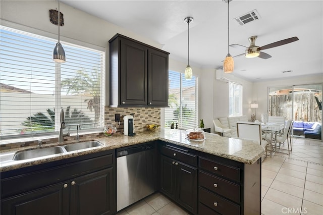 kitchen with a sink, dishwasher, a peninsula, light tile patterned floors, and visible vents