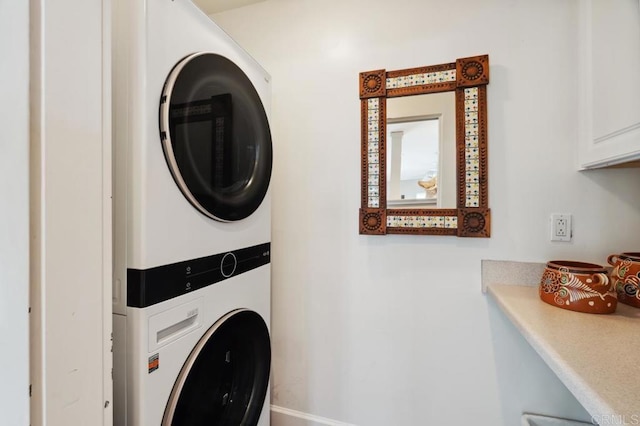 clothes washing area featuring cabinet space and stacked washer / drying machine