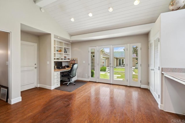 office featuring baseboards, vaulted ceiling with beams, built in desk, and wood finished floors