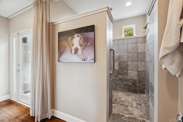 full bathroom featuring baseboards, recessed lighting, and a tile shower