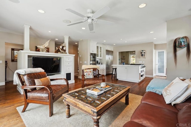 living room featuring recessed lighting, a ceiling fan, baseboards, and dark wood-style floors