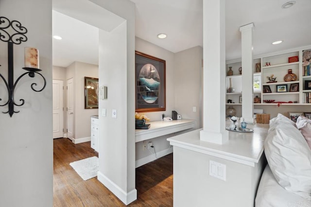walk in closet with ornate columns and wood finished floors