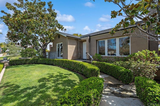 view of front facade with a front lawn and stucco siding