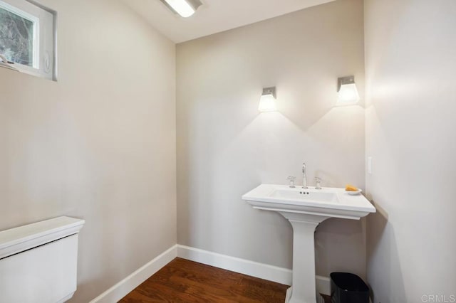 bathroom featuring toilet, baseboards, and wood finished floors