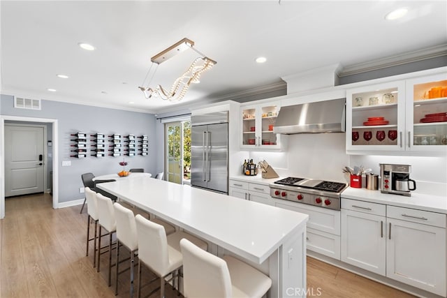 207 Via Galicia, San Clemente, CA 92672 - kitchen with stainless steel appliances, extractor fan, ornamental molding, a kitchen bar, and light countertops
