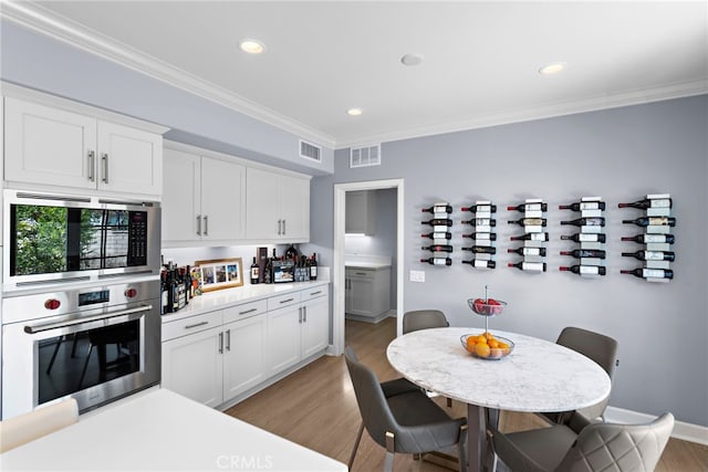 207 Via Galicia, San Clemente, CA 92672 - kitchen featuring stainless steel appliances, light wood finished floors, ornamental molding, white cabinets, and light countertops